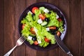 Greek salad (lettuce, tomatoes, feta cheese, cucumbers, black olives) on dark wooden background Royalty Free Stock Photo