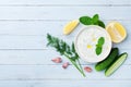 Greek sauce tzatziki from sour cream yogurt on wooden table top view. Traditional mediterranean dip or dressing.