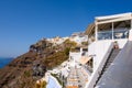 Greek seafront restaurant and houses on the hill in Fira on Santorini Island. Cyclades,