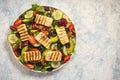 Greek style cuisine - salad with grilled halloumi cheese, avocado, pecan nuts and tomatoes. Royalty Free Stock Photo