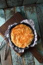 Greek style pastry with phyllo dough. Homemade pie in baking foil on shabby blue background