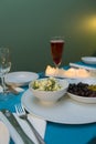 Greek style table arrangement with a plate filled with different types of olives and cheese