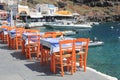 Greek tavern with orange wooden chairs by the sea coast, Greece, Royalty Free Stock Photo