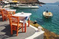 Greek tavern with orange wooden chairs by the sea coast, Greece, Royalty Free Stock Photo