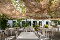 Greek tavern with table and chair under net at Kithira island Milopotamos. Pots with flowers