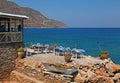 Greek tavern with tables and chairs on rock coast overlooking Me Royalty Free Stock Photo