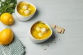 Avgolemono chicken soup with meatballs. Top view on gray light wooden background, with lemons, parsley and a checkered Royalty Free Stock Photo