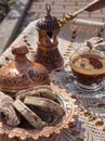 Greek Turkish brewed coffee and marble halva on a table with a handmade tablecloth and a copper coffee maker and candy maker on Royalty Free Stock Photo