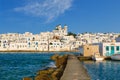 Greek whitewashed houses and church by harbour watersfront on sunny day, Naoussa, Paros island, Greece Royalty Free Stock Photo