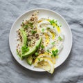 Greek yogurt with avocado, quinoa, greens, spice bowl on grey background, top view. Healthy appetizer, tapas