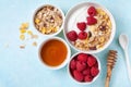 Greek yogurt in bowl with ingredients raspberries, honey and muesli on blue table top view Royalty Free Stock Photo