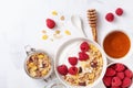 Greek yogurt in bowl with raspberries, honey and muesli on white stone table top view. Healthy diet breakfast Royalty Free Stock Photo