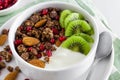 Greek yogurt with chocolate granola, kiwi fruit, pomegranate seeds and almonds in a bowl Royalty Free Stock Photo