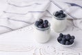 Greek yogurt in a glass jar and fresh blueberries on a rustic white table. Healthy food concept. Selective focus Royalty Free Stock Photo