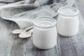 Greek yogurt in a glass jars with wooden spoons on wooden background. Healhty Breakfast Food