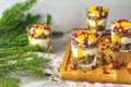 Greek yogurt with granola, orange and pomegranate berries for healthy breakfast on light gray wooden table