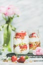 Greek yogurt, granola, strawberry breakfast jars, pink raninkulus flowers Royalty Free Stock Photo