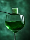 Green absinthe with sugar cube on a spoon over glass. Royalty Free Stock Photo