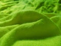 Green abstract background bumps of corrugated cotton fabric.