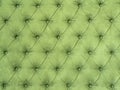 Green abstract background with symmetrical upholstered buttons on fabrics.