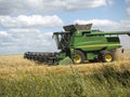 Green Agricultural field on the Harvester gathers the wheat. Agricultural machinery for harvesting. Concept of agriculture.