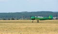 Green airplane with propeller on airfield