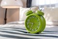Green alarm clock on bed