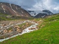 Mountain stream flows down from a glacier. Beautiful alpine landscape with a fast river. The power of the majestic nature of the Royalty Free Stock Photo
