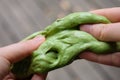 Green anti stress toy slime with glitter in hands. Fighting anxiety and stress. Creative game experiment for children.