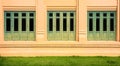 Green antique wood window at pale orange building. Royalty Free Stock Photo