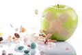 Green apple with a band-aid and varios pills Royalty Free Stock Photo