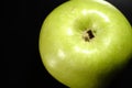 A green apple on a black background. Closeup. Royalty Free Stock Photo
