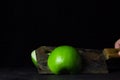 Green apple on a black background. kitchen hatchet chopping an apple in half.