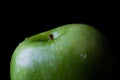 Green apple on black from side closeup Royalty Free Stock Photo