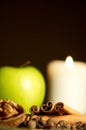 Green apple, cinnamon, walnut and a candle Royalty Free Stock Photo