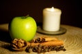 Green apple, cinnamon, walnut and a candle on the table Royalty Free Stock Photo
