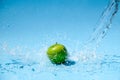 Green apple in clear water splash
