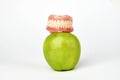 Green apple and dentures on white background Royalty Free Stock Photo