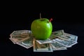 Green apple on dollars cash