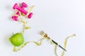 Green apple, dumbbell and tape measure on white table background. Selection of healthy food and exercise concept. Organic food, Royalty Free Stock Photo