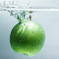 Green apple falling water on white background. Royalty Free Stock Photo