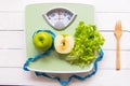 Green apple, fresh vegetable with weight scale and measuring tape for the healthy diet slimming