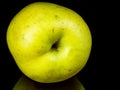 Green apple fruit on a black glass background with reflection Royalty Free Stock Photo