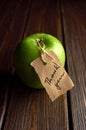 Green apple gift with thank you lable on dark wooden table background. Teachers day concept