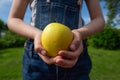 A green apple in a hand reaching out