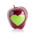 Green apple heart shape in red apple. Royalty Free Stock Photo