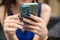 Green Apple iPhone 13 pro in the hands of a woman in a blue dress and with blue nails