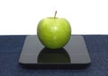 Green apple on kitchen scales closeup Royalty Free Stock Photo