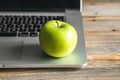 Apple near laptop at workplace, healthy snack. Royalty Free Stock Photo