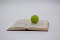 Green apple on open book Royalty Free Stock Photo